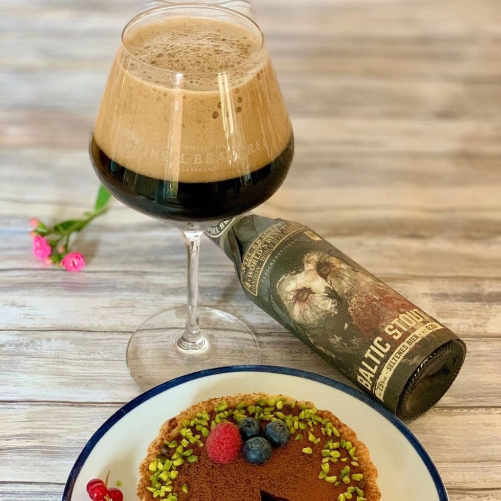 Sobremesas e Beer Pairing: 7 cervejas para sobremesas. Na imagem copo e garrafa de Insel Baltic Stout, bolo de Chocolate com frutos vermelhos, framboesas e mirtilos